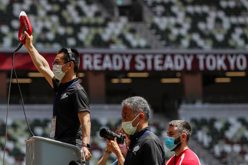 Officials are seen wearing masks during the morning session of the athletics test event. Reuters