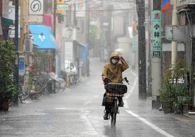 A woman cycles under heavy rain in Tokyo. EPA