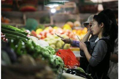 People shop for vegetables in a market in Beijing. China's food and housing costs, which includes utilities and rent, have outpaced overall inflation, soaring 11 per cent and 6.5 per cent respectively in the first quarter, increasing pressure on households already battling to make ends meet. Peter Parks / AFP Photo