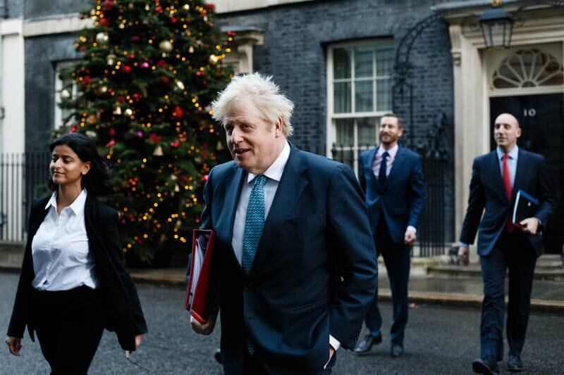 Boris Johnson passes a Christmas tree as he leaves 10 Downing Street for the weekly Cabinet meeting on December 15, 2020. Getty Images