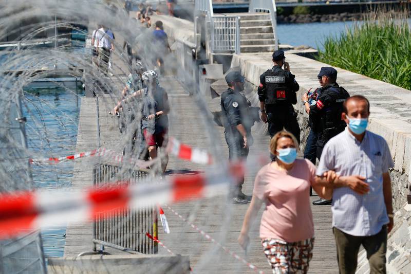 Swiss police officers patrol near temporary security fencing along the waterfront near Villa La Grange. Bloomberg