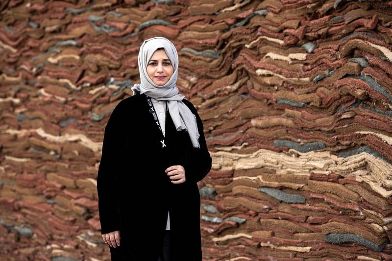 Saudi Arabian artist Zahrah Alghamdi poses in front of her art installation 'What Lies Behind the Walls', displayed as part of the Desert X exhibition near Palm Springs, California. EPA