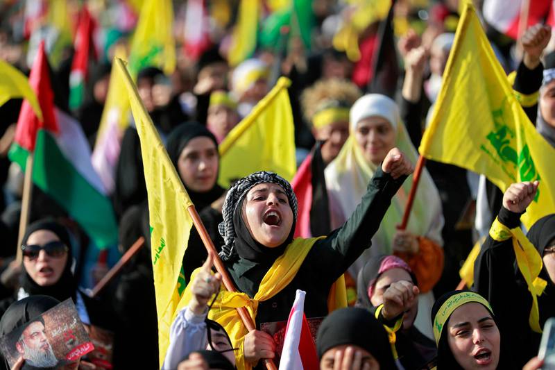Supporters of Hezbollah wave flags as they watch a televised speech by its leader Hassan Nasrallah in the Lebanese capital Beirut's southern suburbs on Friday. AFP