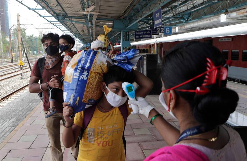 A health worker checks the body temperature of a traveller at a train station in Mumbai, India. AP Photo