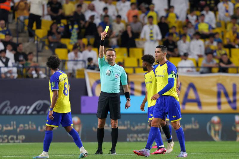 Latvian match referee Andris Treimanis shows a yellow card. AFP