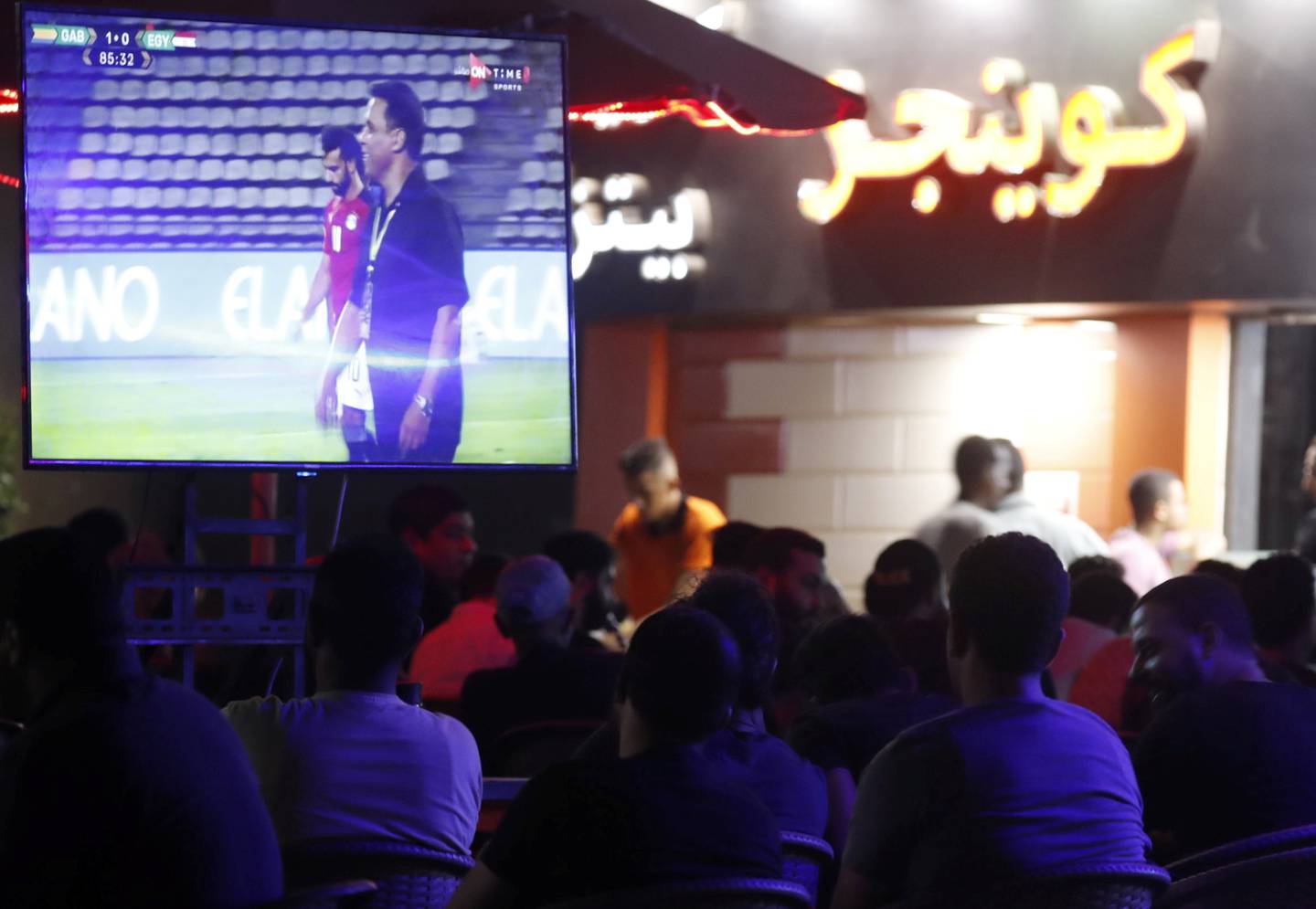 Egypt fans in Cairo cafe look on as star striker Mohamed Salah and manager Hossam El-Badry appear on television during the World Cup qualifying match against Gabon. Reuters 