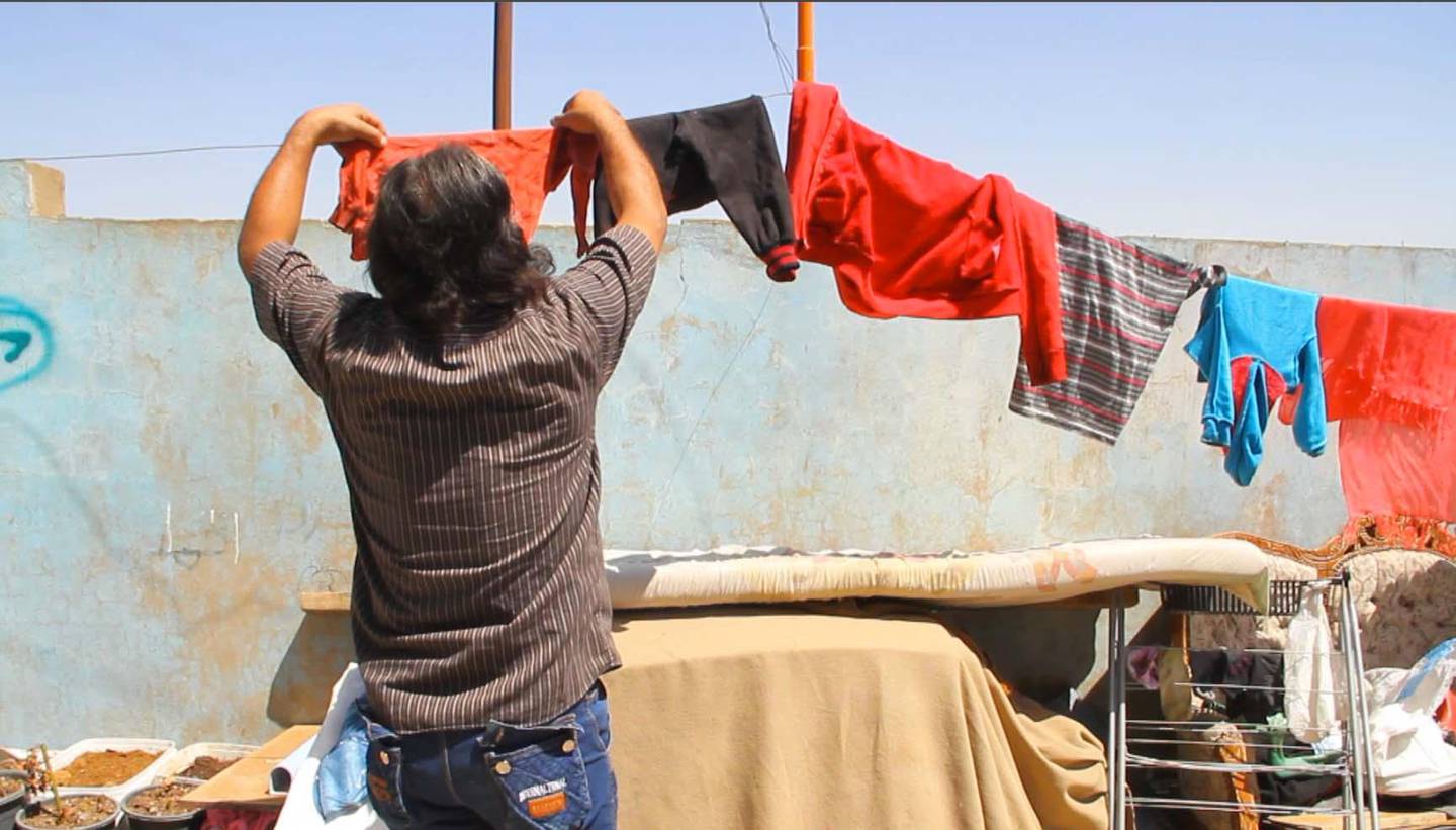 Abu Khalil hangs laundry in the documentary Men on Hold. Courtesy Forward Film Productions/Muna Khalidi
