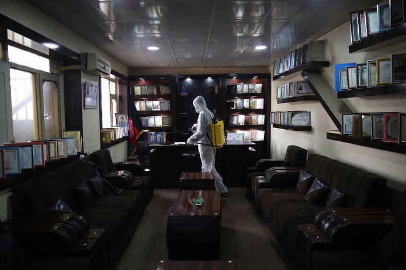 A volunteer in a protective suit sprays disinfectant in the offices of a local police station to help curb the spread of coronavirus in Kabul, Afghanistan, on March 23, 2020. AP Photo