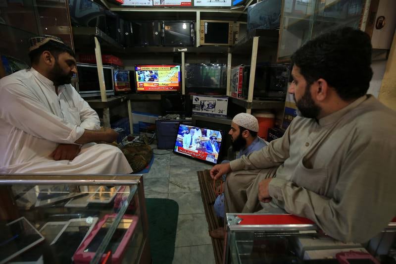 People in Pakistan watch a televised speech by newly elected prime minister Shahbaz Sharif. AP
