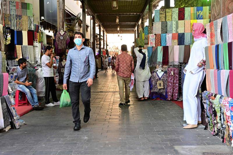 People walk past shops in Dubai's Deira Souk on on March 15, 2020. AFP