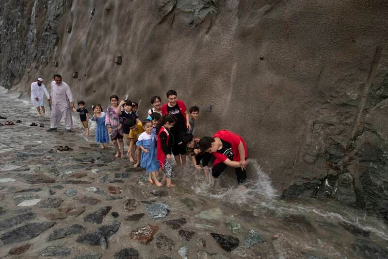 Children play in the water flowing down the side of the road. Ruel Pableo for The National