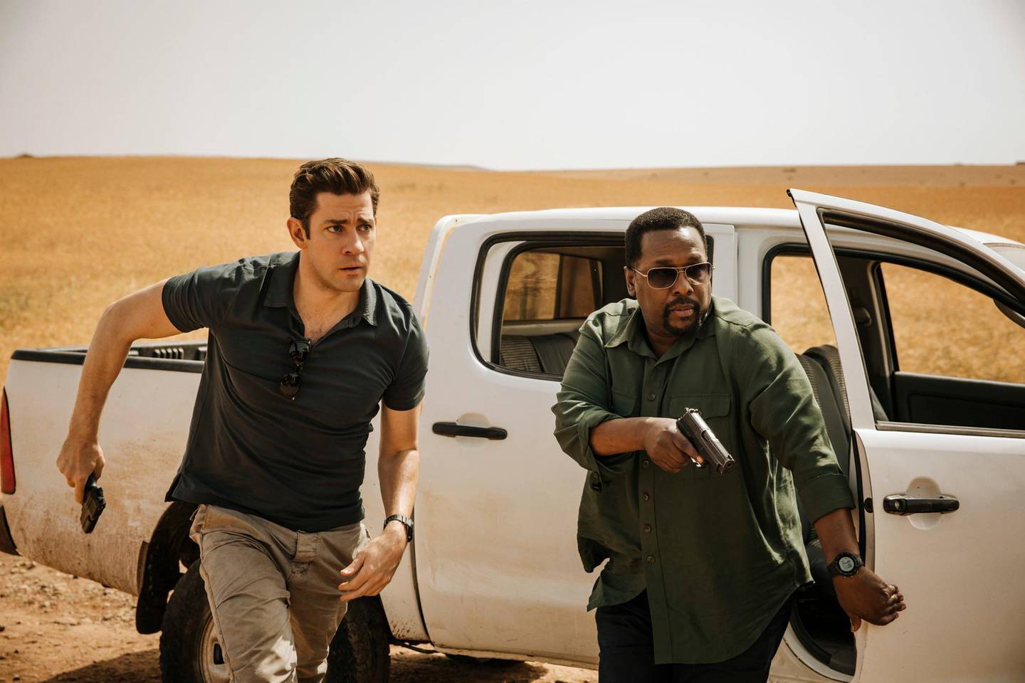 This image released by Amazon shows John Krasinski, left, and Wendell Pierce in a scene from "Tom Clancy's Jack Ryan." (Jan Thijs/Amazon via AP)