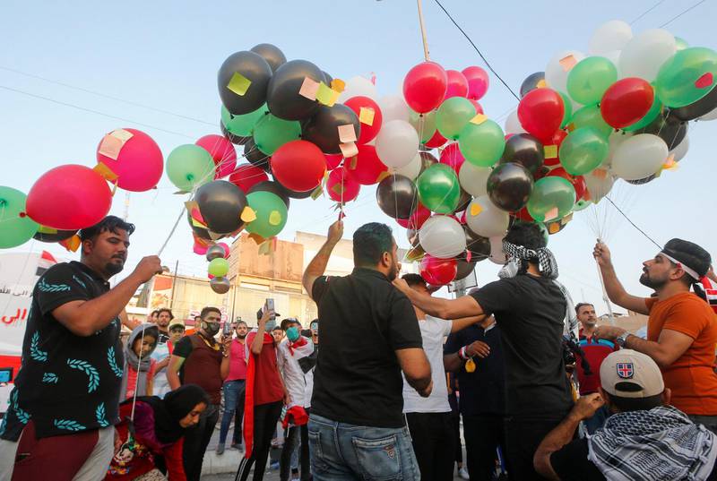 A group of activists gather to launch balloons carrying demonstrators' "messages to god" during an anti-government protest in front of government building in Basra. Reuters