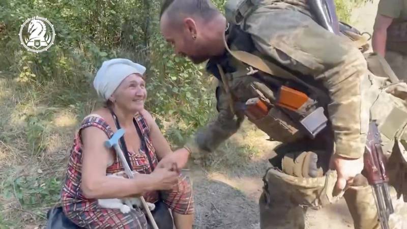 A Ukrainian soldier greets a woman liberated from Robotyne. Reuters
