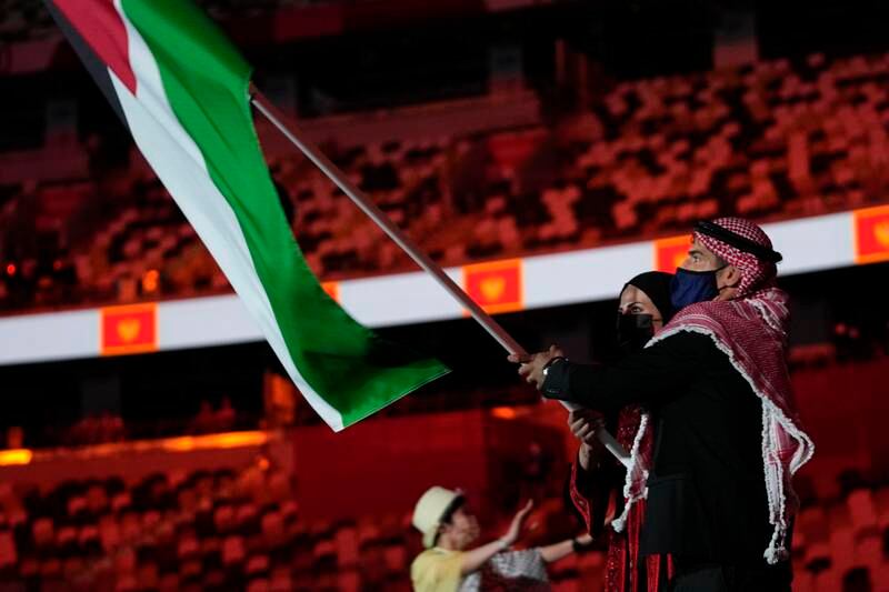 Julyana Al-Sadeq and Zeyad Eashash, of Jordan, carry their country's flag during the opening ceremony.