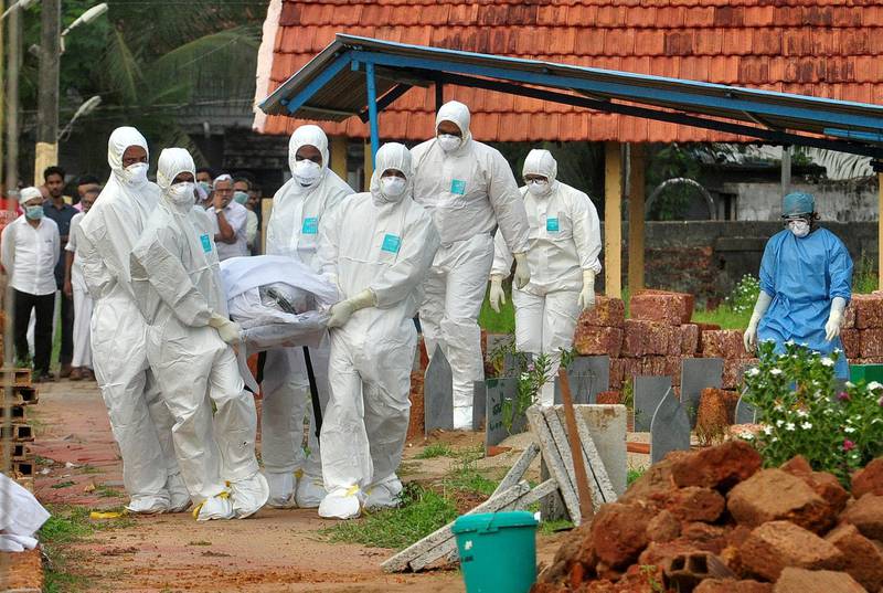 FILE PHOTO: Doctors and relatives wearing protective gear carry the body of a victim, who lost his battle against the brain-damaging Nipah virus, during his funeral at a burial ground in Kozhikode, in the southern Indian state of Kerala, India, May 24, 2018. REUTERS/Stringer/File Photo