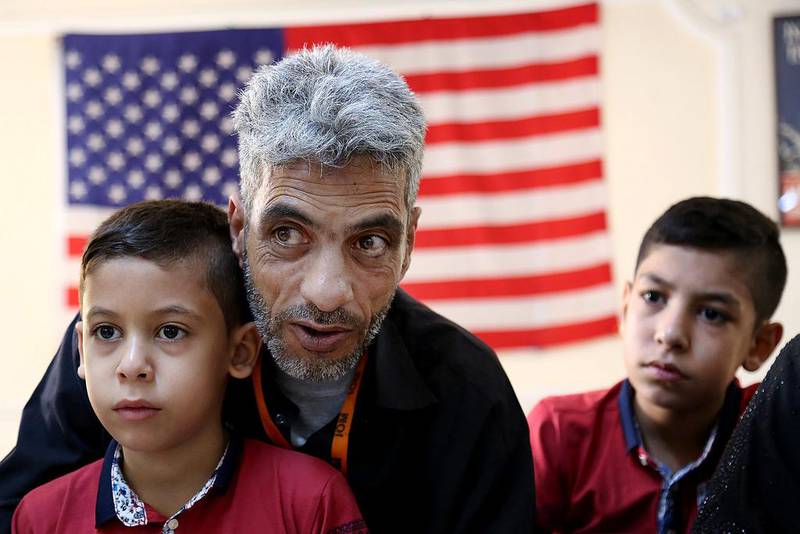 A Syrian refugee and his two children at the International Organisation for Migration in Amman, Jordan. AP