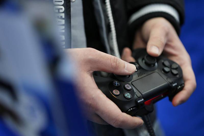 A customer plays a video game on a Sony Computer Entertainment Inc. PlayStation 4 (PS4) video game console at a Bic Camera Inc. electronics store in Tokyo, Japan, on Saturday, Feb. 22, 2014. Sony Corp., its credit rating cut to junk by Moody's Investors Service as Japan's biggest television maker struggles to capture consumer demand for smartphones and tablet computers, released the PS4 console in Japan today. Photographer: Kiyoshi Ota/Bloomberg