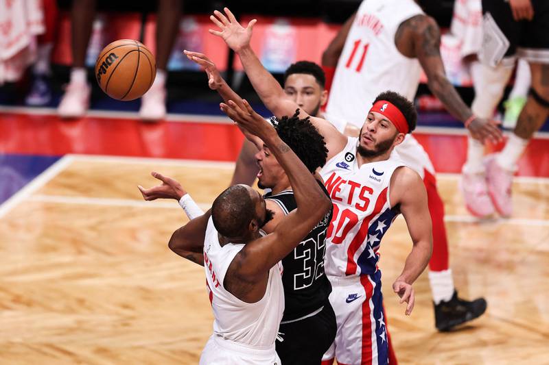 Tre Jones of the San Antonio Spurs passes the ball while guarded by Seth Curry and Kevin Durant. Getty
