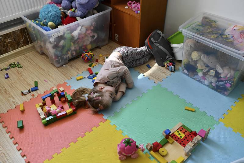A girl from Ukraine rests on the floor in the Budapest hostel for refugees. AP