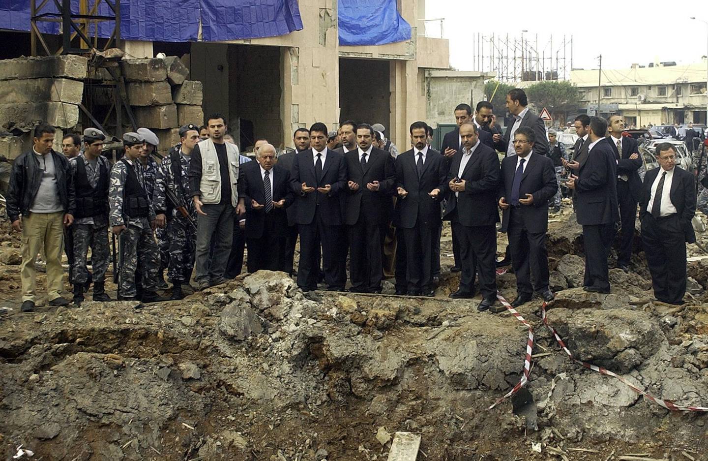 (FILES) In this file photo taken on February 19, 2005, three of the sons of slain Lebanese prime minister Rafiq Hariri Ayman, Saadeddin, and Bahaa (C) pray at the site of a massive explosion in which their father was killed along with 14 people in central Beirut. On Valentine's Day 2005, the former prime minister Rafic Hariri who embodied the reconstruction of the country after its 1975-1990 civil war was killed in a monster bomb attack on his convoy. The special tribunal trying the four suspects accused of the 2005 assassination is expected to deliver its verdict on on August 18, 2020. / AFP / -
