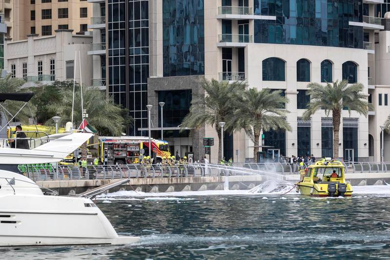 DUBAI, UNITED ARAB EMIRATES. 24 JANUARY 2020. Civil Defense extinguise the remains of a yacht that burnt out in the Dubai Marina. (Photo: Antonie Robertson/The National) Journalist: None. Section: Sport.