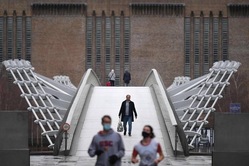 People walk across Millennium bridge in central London. AFP