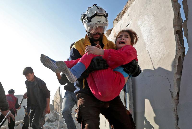 A member of the Syrian Civil Defence, also known as the White Helmets, carries a wounded girl after a team rescued her from the rubble of a building following a reported Russian air strike in the village of Tal Mardikh. AFP