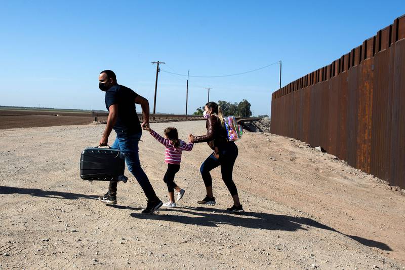 A Cuban family of migrants run across an open section of road at the US-Mexico border in Arizona. AFP