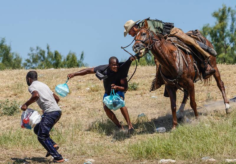 A US Border Patrol agent on horseback tries to stop a Haitian migrant from entering an encampment on the banks of the Rio Grande in Del Rio, Texas on September 19. AFP