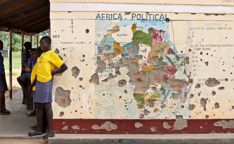 FILE - In this Nov. 15, 2016 file photo, students line up outside a classroom with a map of Africa on its wall, in Yei, in southern South Sudan. The United States is poised to permanently lift sanctions on Sudan, U.S. officials said Oct. 5, 2017, recognizing the long-estranged country's progress on human rights and counterterrorism after decades of war and abuses. The Trump administration will complete a process that former President Barack Obama started in January, when he temporarily lifted the penalties. (AP Photo/Justin Lynch, File)
