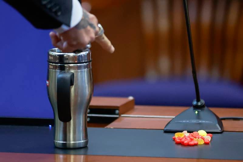 Depp points at a pile of sweets in the courtroom. AP
