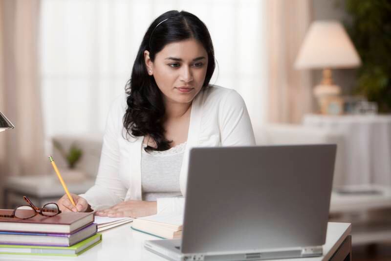 Mixed race woman studying on laptop