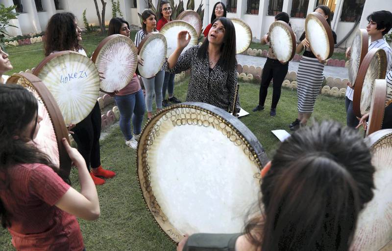 Young Yazidi and Muslim women, part of the musical group "40 Plaits," rehearse a traditional Kurdish song accompanied by the Daf, a large Kurdish frame drum, in a community centre in Dahuk, about 260 miles (430 kilometers) northwest of the Iraqi capital Baghdad, on June 25, 2019. (Photo by SAFIN HAMED / AFP)