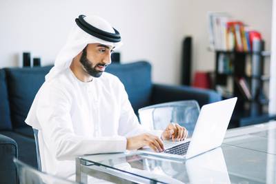 Arab man browsing social networks and doing business online using his laptop at home. Image contains some copy space.