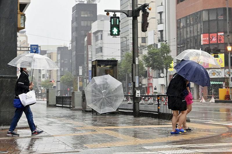 Pedestrians brave the bad weather in Matsuyama, Japan. AP