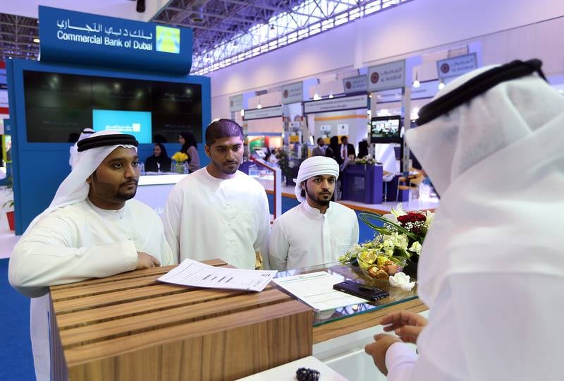 Sharjah, United Arab Emirates- February, 11, 2015:  Young emiratis ( L to  R ) Khalid Moosa Al Maazmi, Ahmed Moosa Al Maazmi and Saeed Al Shamshi from university of Sharjah  submit their  job applications to Adel Al Shirawi, recuritment officer at the Dubai Islamic Bank stand  during the National Career Exhibition at the Expo centre in Sharjah . ( Satish Kumar / The National )  For News / Story by Thaer Zuriekat Zriqat *** Local Caption ***  SK-NationalCareer-11022015-04.jpg