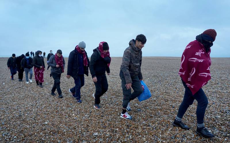 A group of people thought to be migrants arrive in Dungeness, Kent, in the UK following a small boat incident in the English Channel. PA