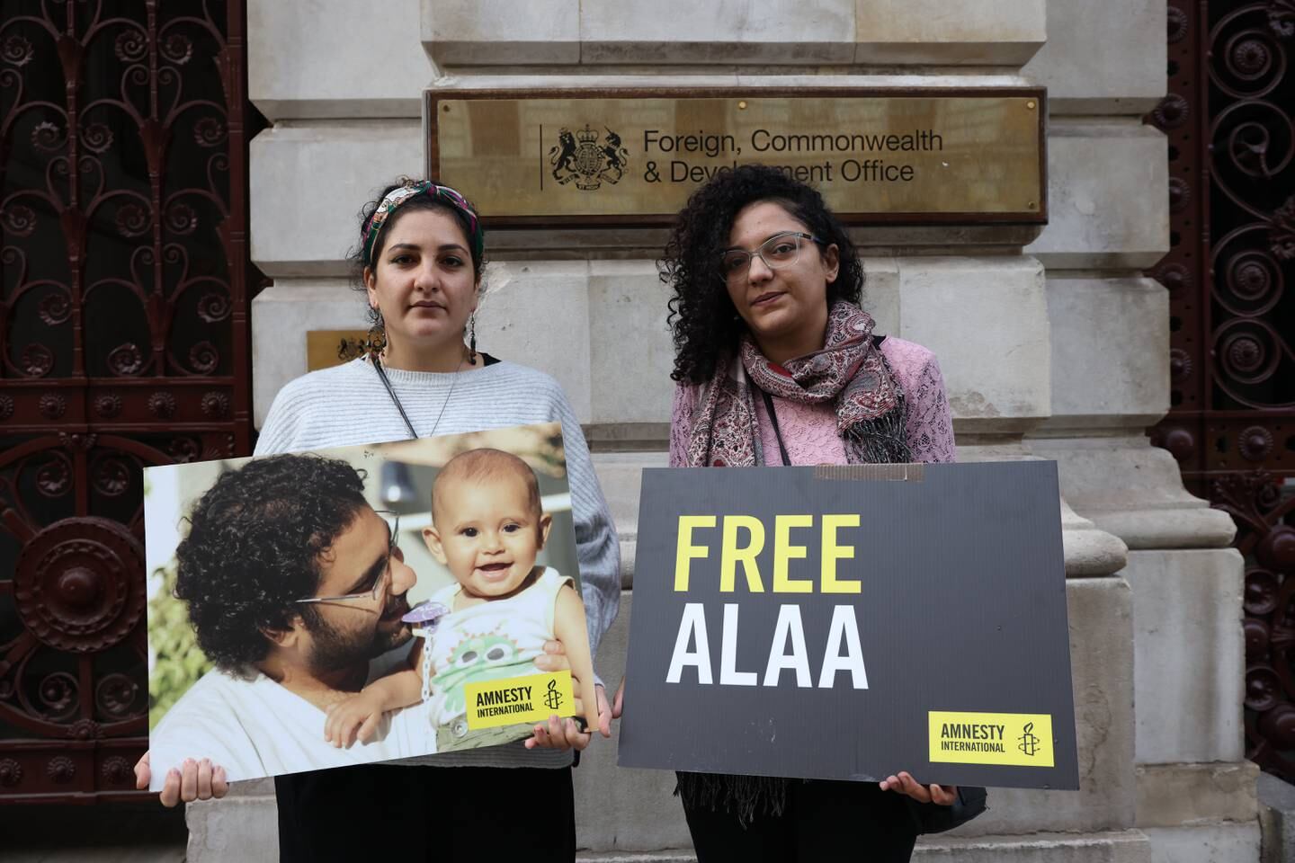 Mona Seif, left, and her sister Sanaa hold placards calling for the release of their brother, Alaa Abdel Fattah, outside the Foreign, Commonwealth and Development Office in London, last month. Getty 
