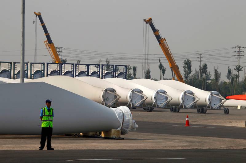 A security guard stands next to blades and bases for wind turbines in the grounds of the Vestas Wind Technology company's factory, located in the northern Chinese city of Tianjin. REUTERS