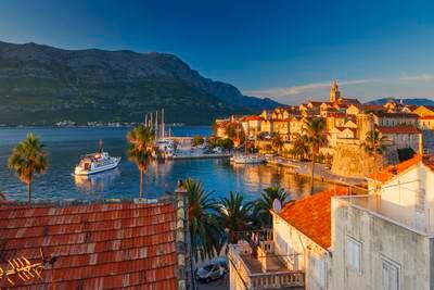 Croatia, Dalmatia, Dalmatian coast, Korcula Island, Korcula, view of a fortified village by the sea with yachts moored at sunset (Getty Images) *** Local Caption ***  wk02ju-tr-cruises-croatia.jpg