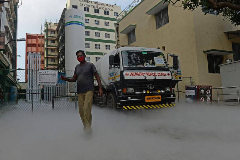 Medical staff can be seen at a spot where a liquid oxygen transportation truck gets refilled at a production plant amid Covid-19 coronavirus pandemic at a hospital in Chennai on April 25, 2021. / AFP / Arun SANKAR                        
