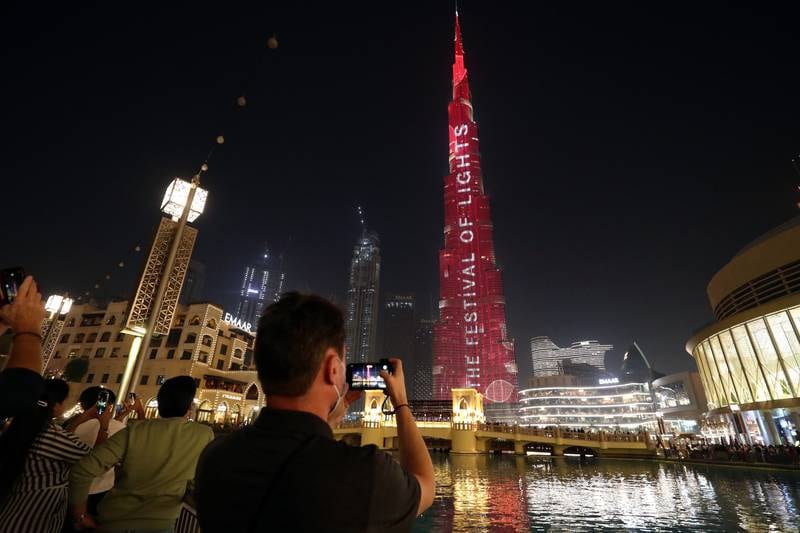 Visitors admire the Burj Khalifa, which has lit up for Diwali celebrations. Chris Whiteoak / The National
