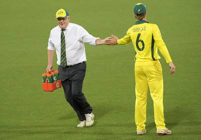 Australia PM Scott Morrison carries drinks during the tour match at the Manuka Oval. Getty Images