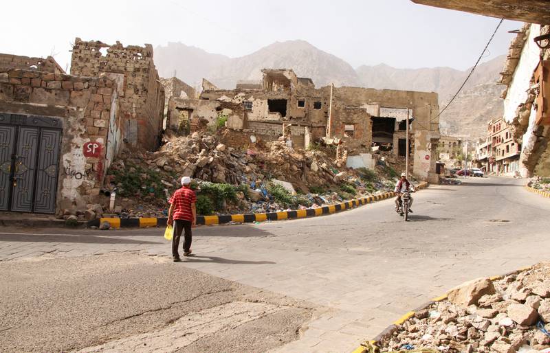 A man walks past buildings damaged by war in Taez, Yemen. Reuters
