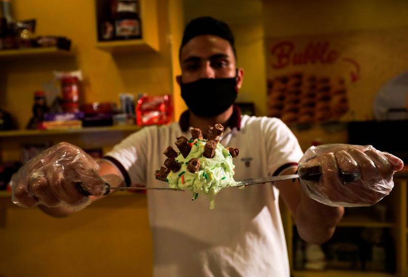 Mahmoud Islam, 24, shows a coronavirus-shaped ice cream inside the Roll Zone shop in the Cairo neighbourhood of Giza, Egypt. Reuters