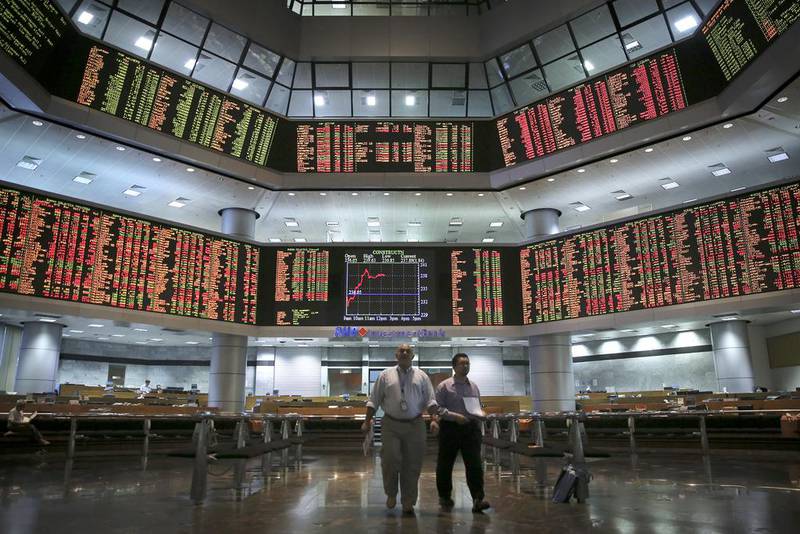 Men monitor trading boards at a stock market gallery in Kuala Lumpur, Malaysia. Vincent Thian / AP Photo