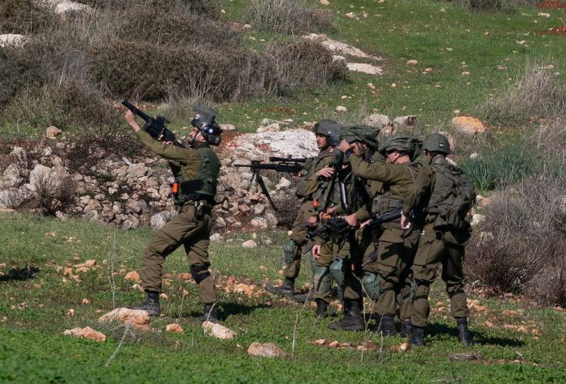 Israeli soldiers take aim to disperse Palestinians protesting the expansion of settlements near the village of Beit Dajan, east of Nablus, in the occupied West Bank, on December 25, 2020. / AFP / JAAFAR ASHTIYEH

