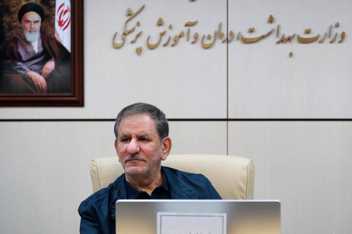 In this Feb. 28, 2020 photo, released by official website of the Office of the Iranian Vice-President, Senior Vice-President Eshaq Jahangiri sits in front of a painting of the late revolutionary founder Ayatollah Khomeini during a top-level meeting on prevention and combating the coronavirus, in Tehran, Iran. Jahangiri and two other Cabinet members have contracted the new coronavirus, semiofficial Fars News Agency reported Wednesday, March 11, 2020. The vast majority of people recover from the new virus. (Office of the Iranian Vice President via AP)