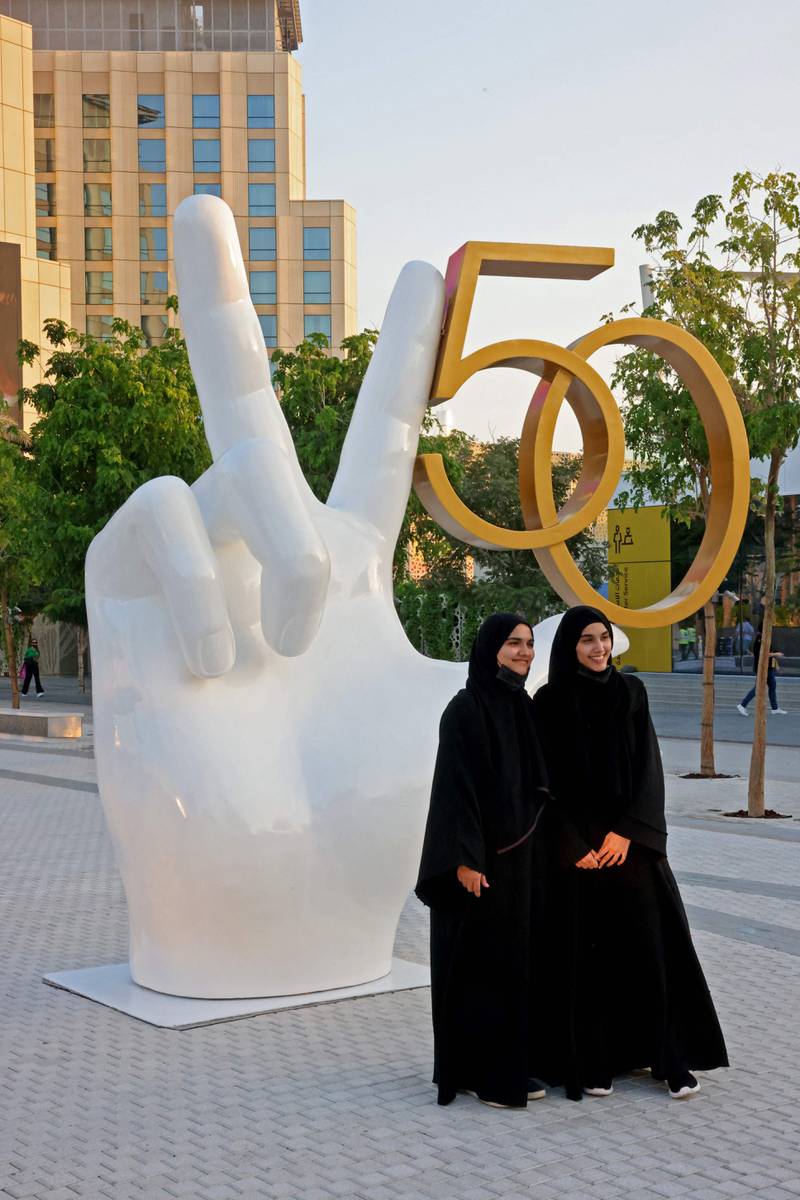 Two visitors pose for pictures at Expo 2020. AFP